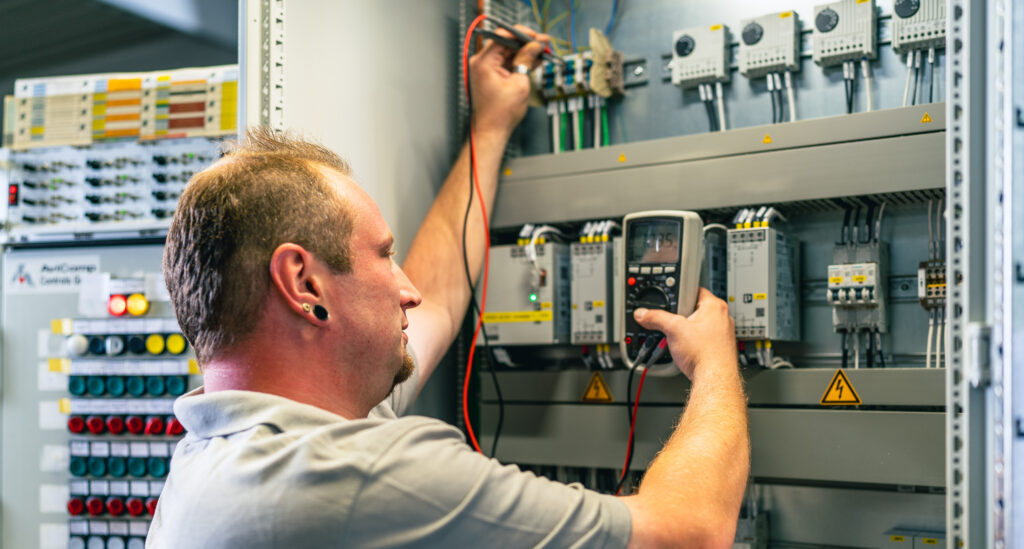 Technician checks in the control cabinet - Techniker prüft im Schaltschrank